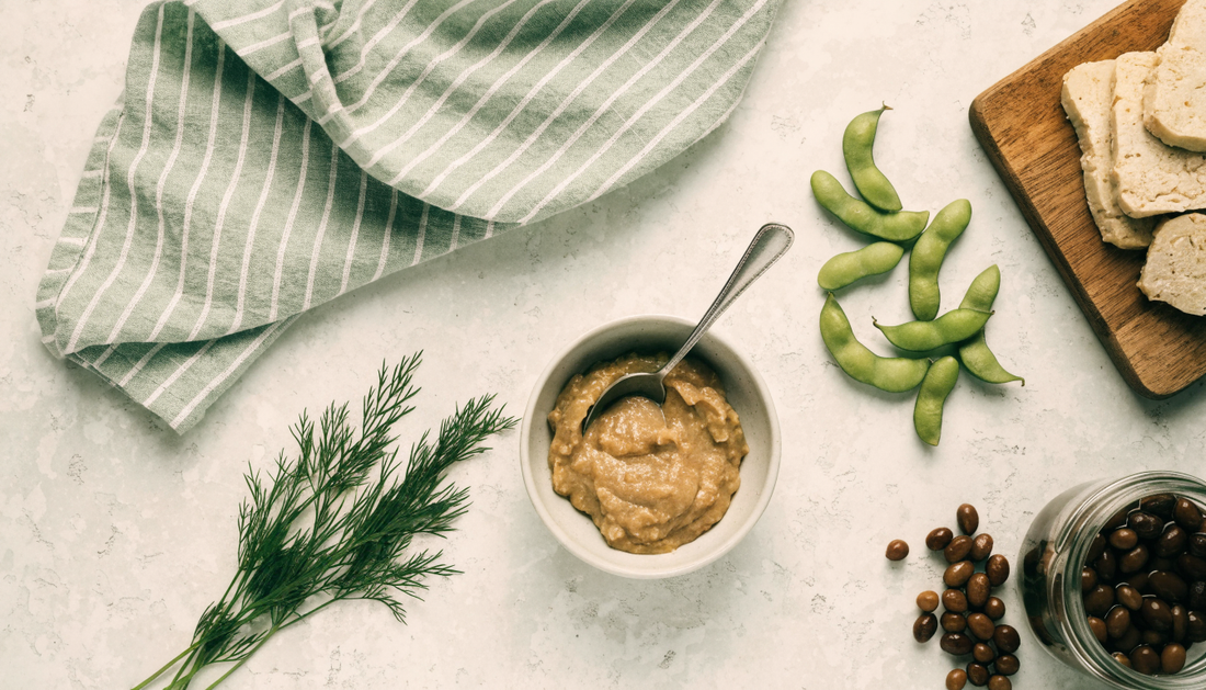 Flat lay of gut-friendly fermented foods including miso, tempeh, fermented soybeans, and edamame