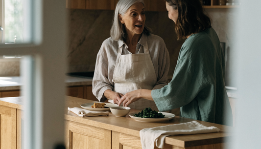 Two women preparing a simple meal of tempeh, miso, and steamed greens at a sunlit kitchen counter, illustrating whole soy foods as an alternative to isoflavone supplements.