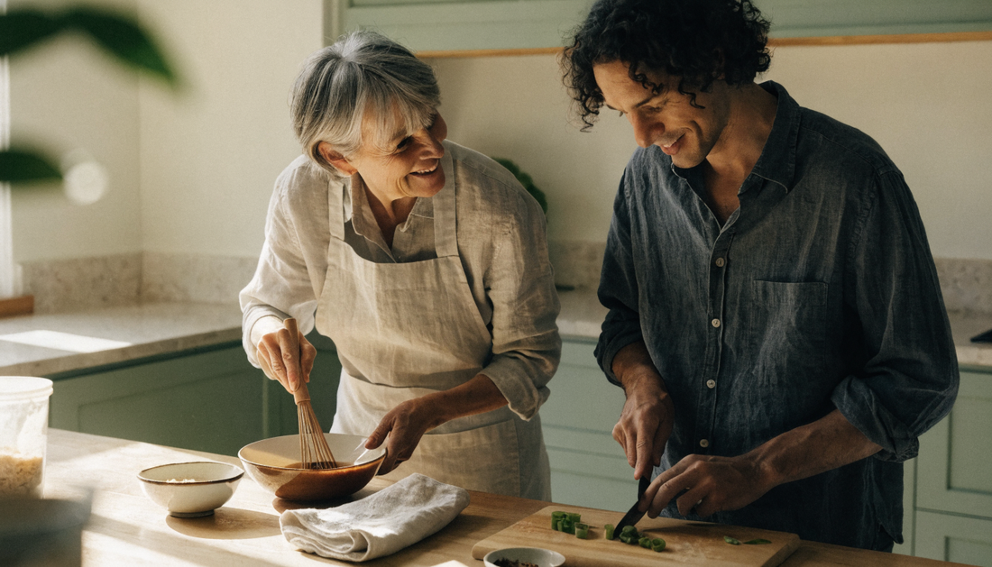 Two home cooks whisking miso into broth and slicing scallions together in a bright, sunlit kitchen